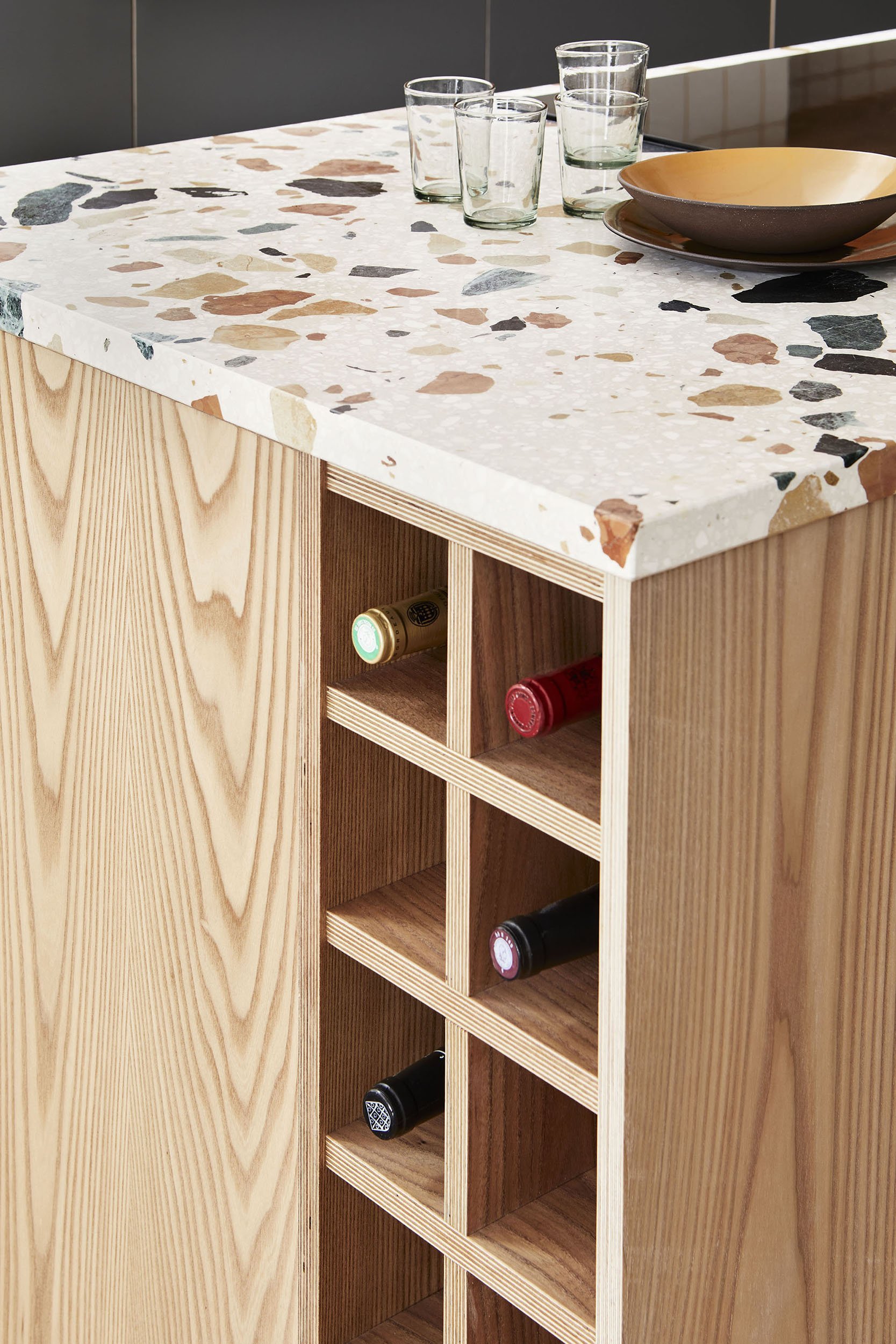 marmoreal work top by Dzek with a bespoke wine rack in American red elm
