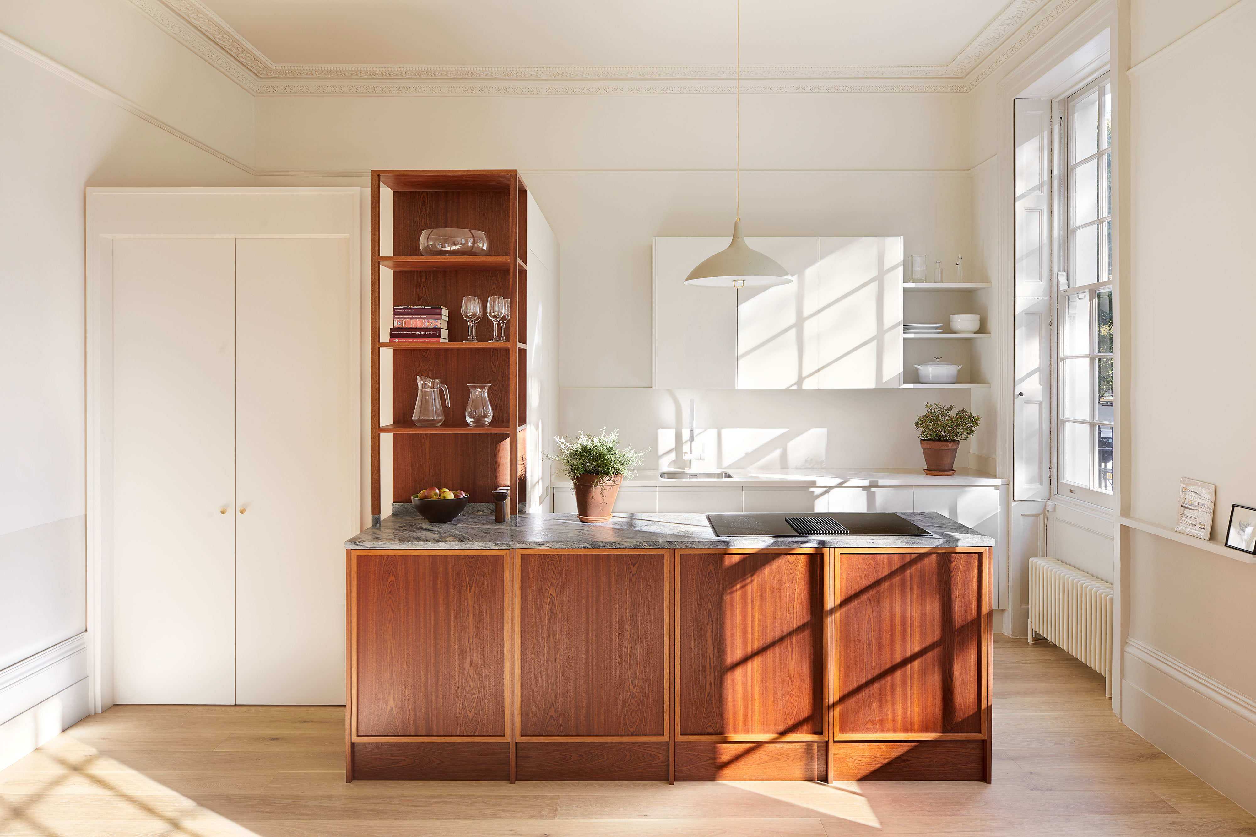 dark wood kitchen in sunlight with white walls