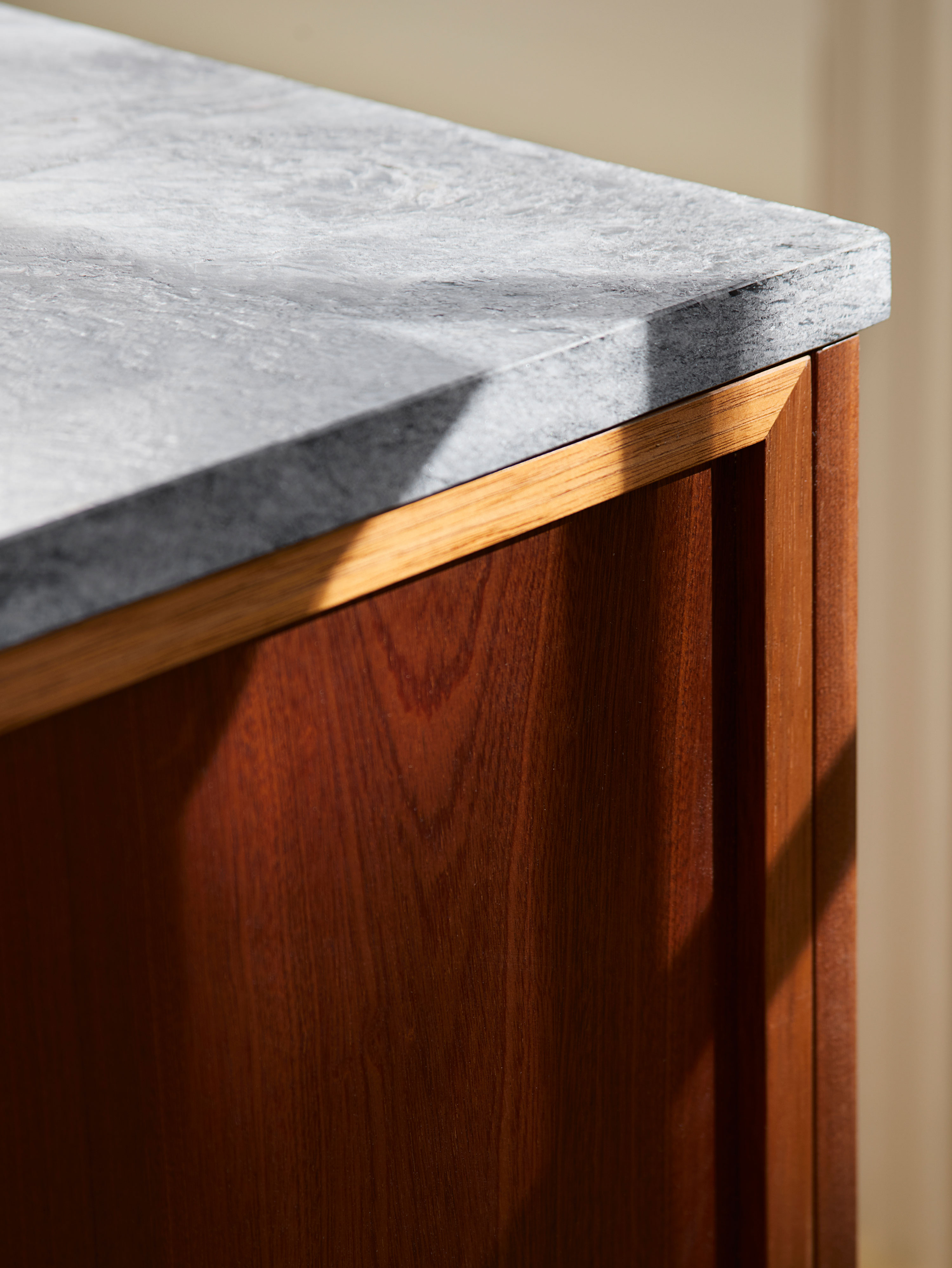 Dark wood cupboard with granite worktop and sunlight