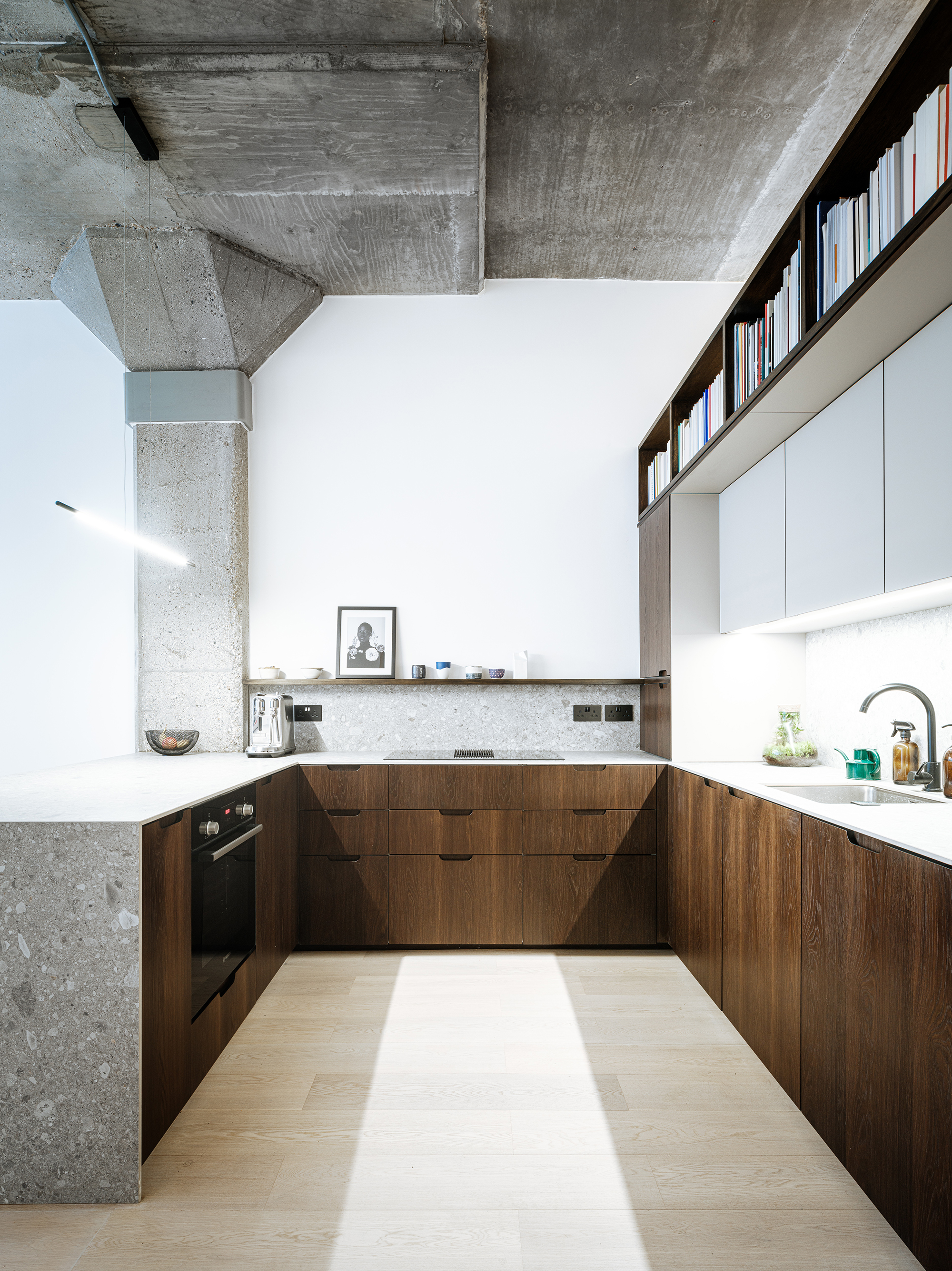 GALLEY KITCHEN DARK WOOD AND CONCRETE WALLS