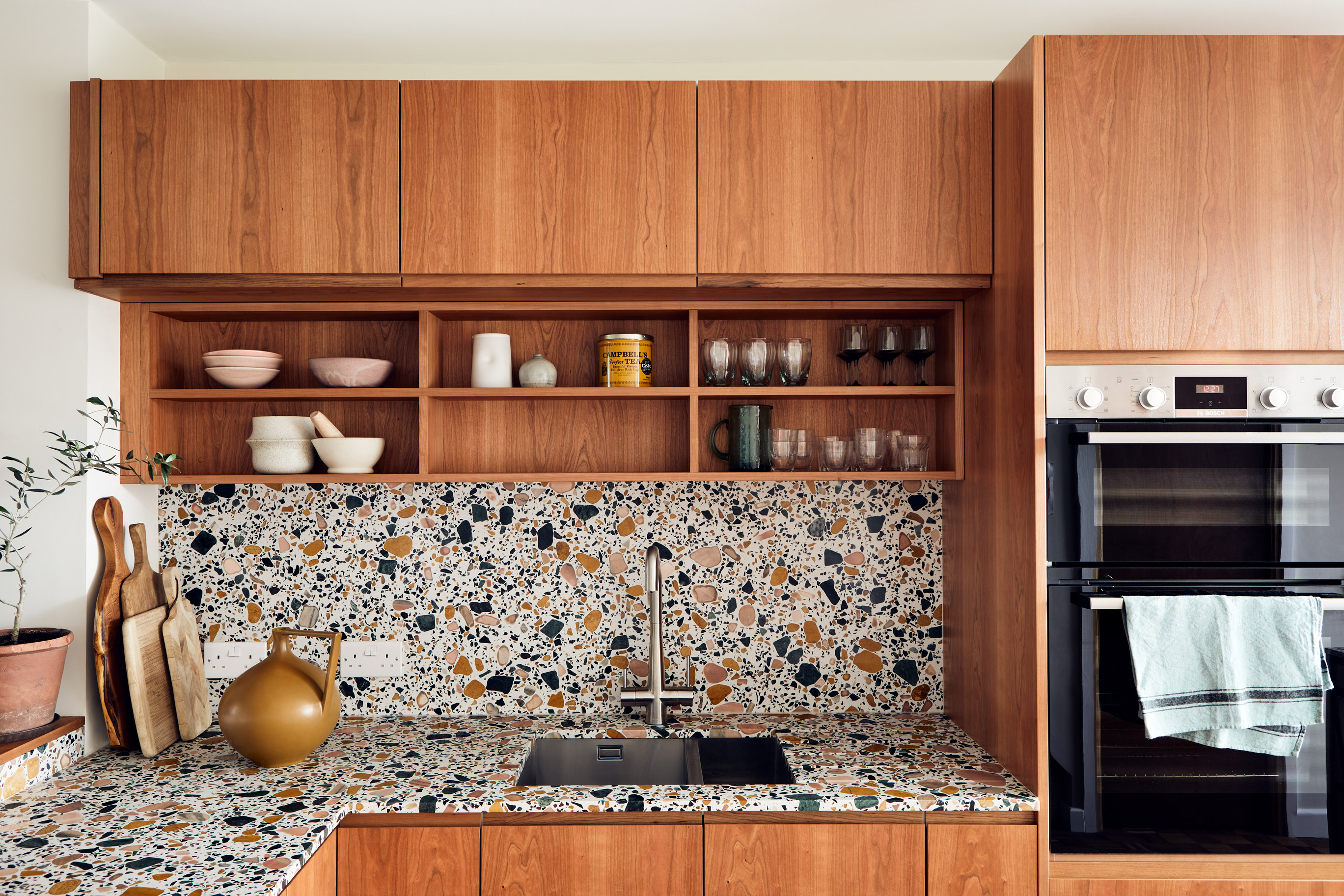 wood kitchen with open shelves and terazzo worktop