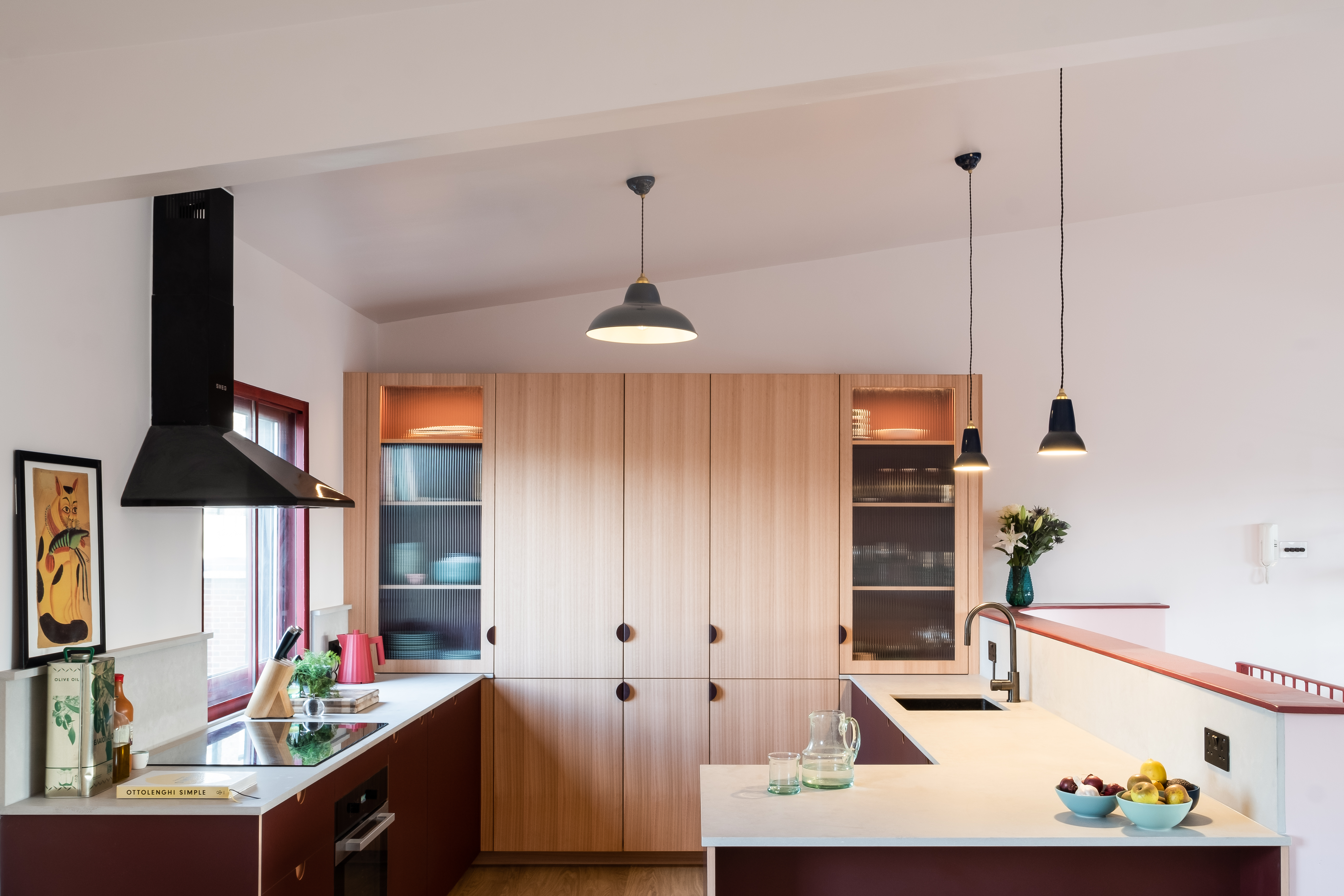 wood kitchen white worktop red doors hanging pendant lights