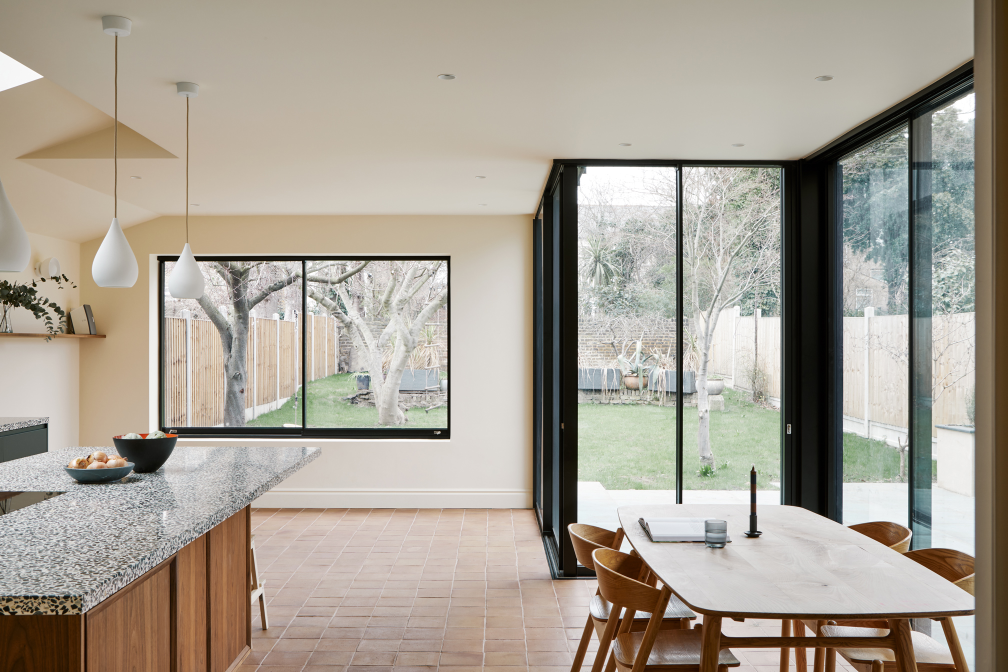 wood cabinets dining table and large windows to garden