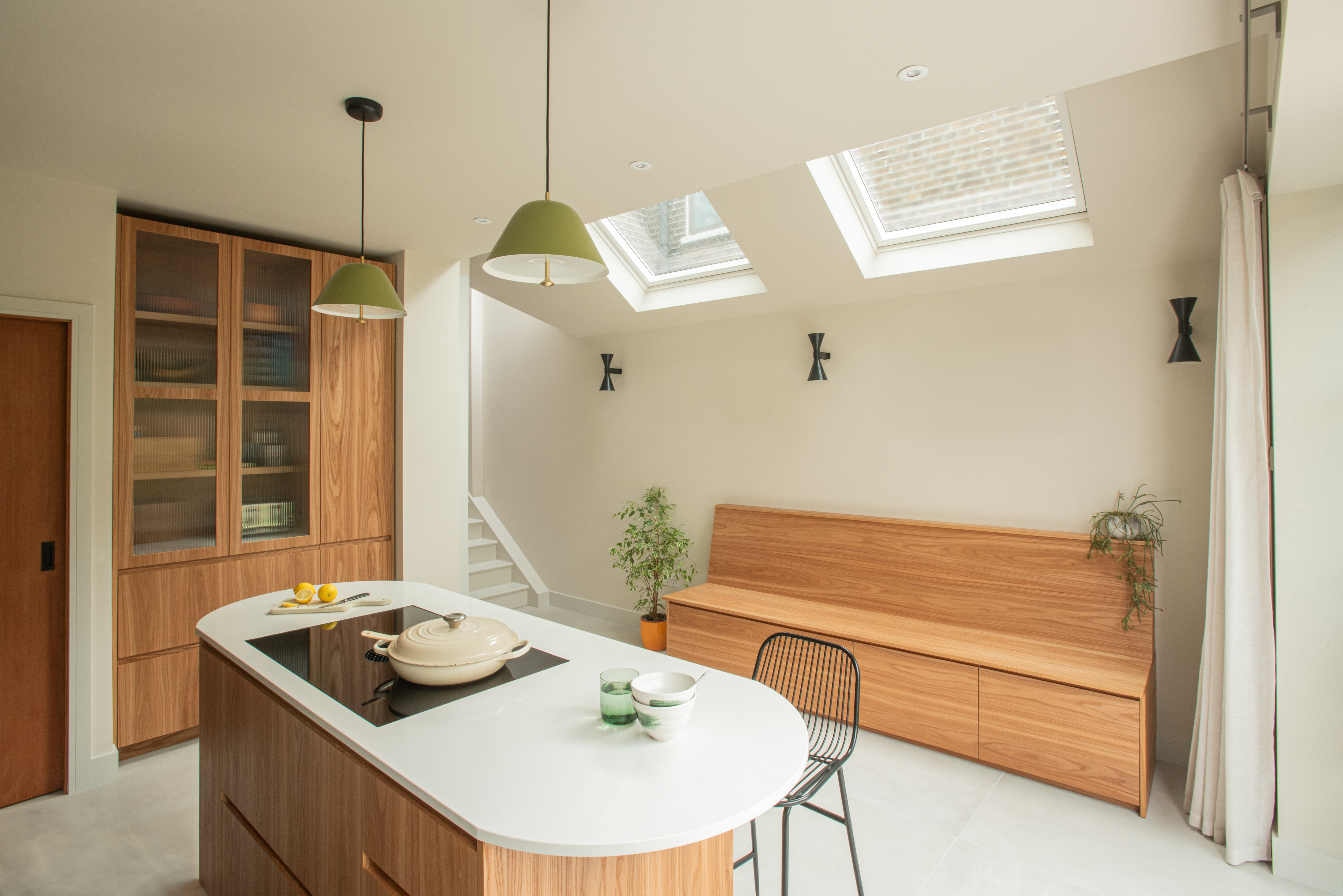 wood and green kitchen with island and external doors to garden