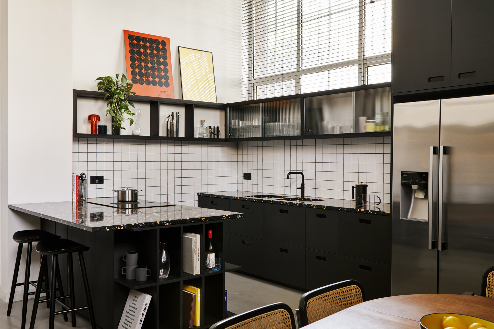 black kitchen with glass cabinets and black stone worktop