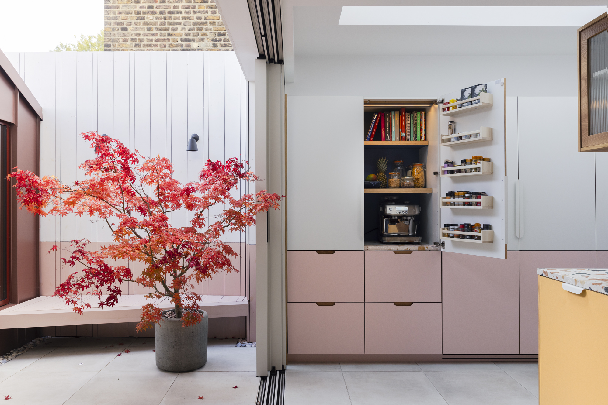 pink white blue and yellow kitchen with white worktop