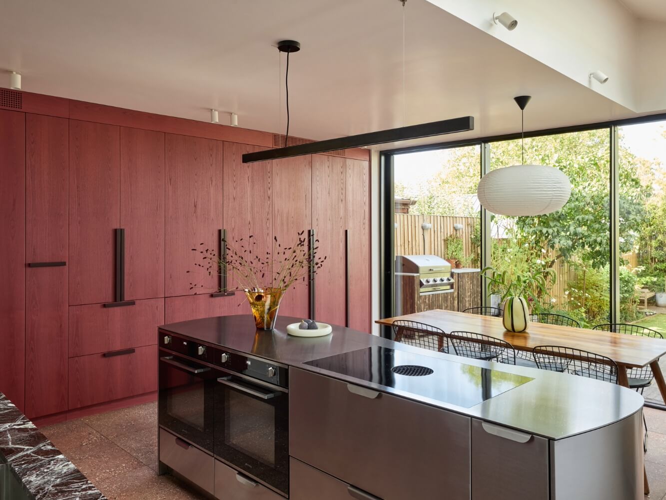 Bespoke red stained kitchen with stainless steel island and marble worktop