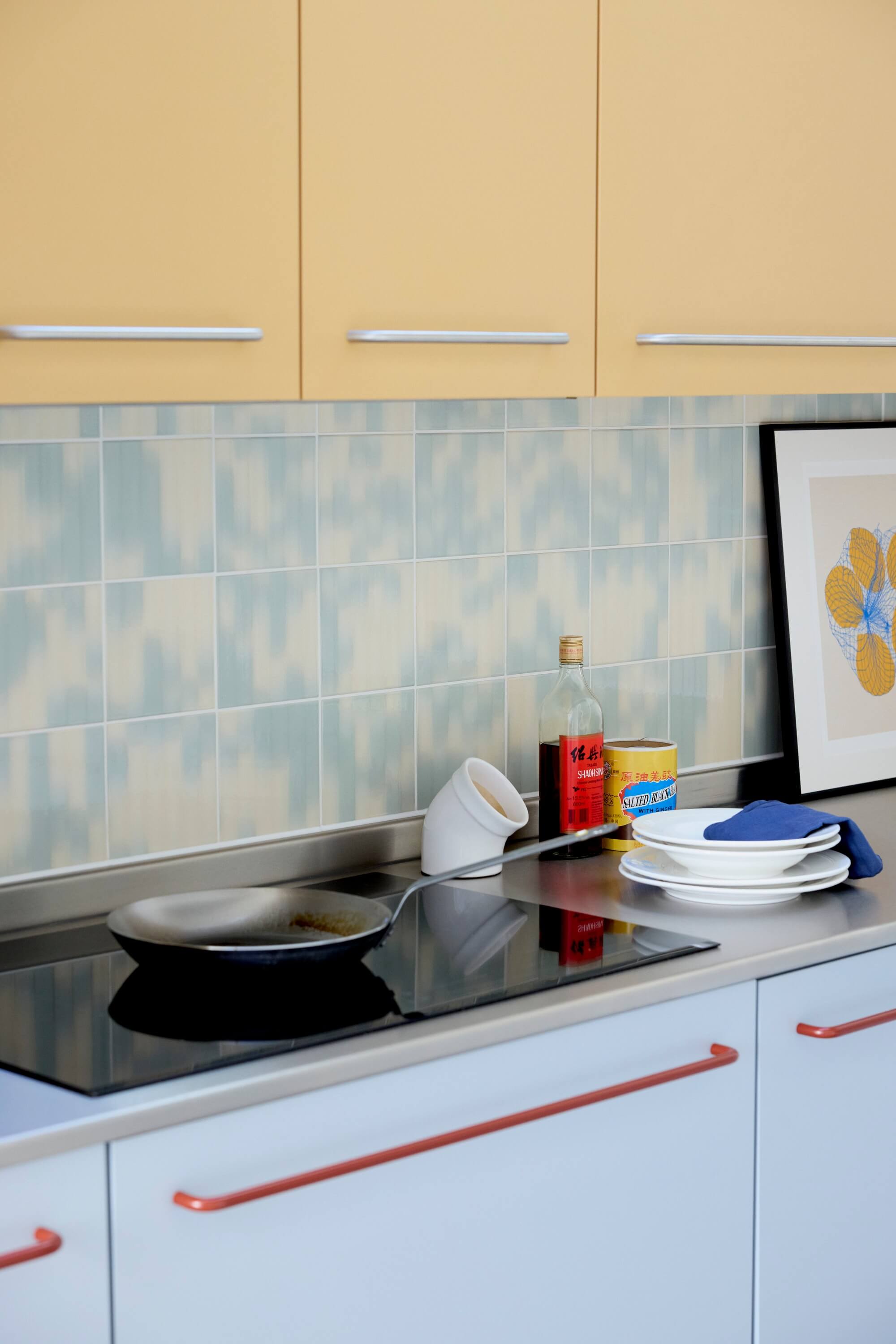 Portrait Image of Vibrant Blue and Yellow Kitchen with Induction Hob