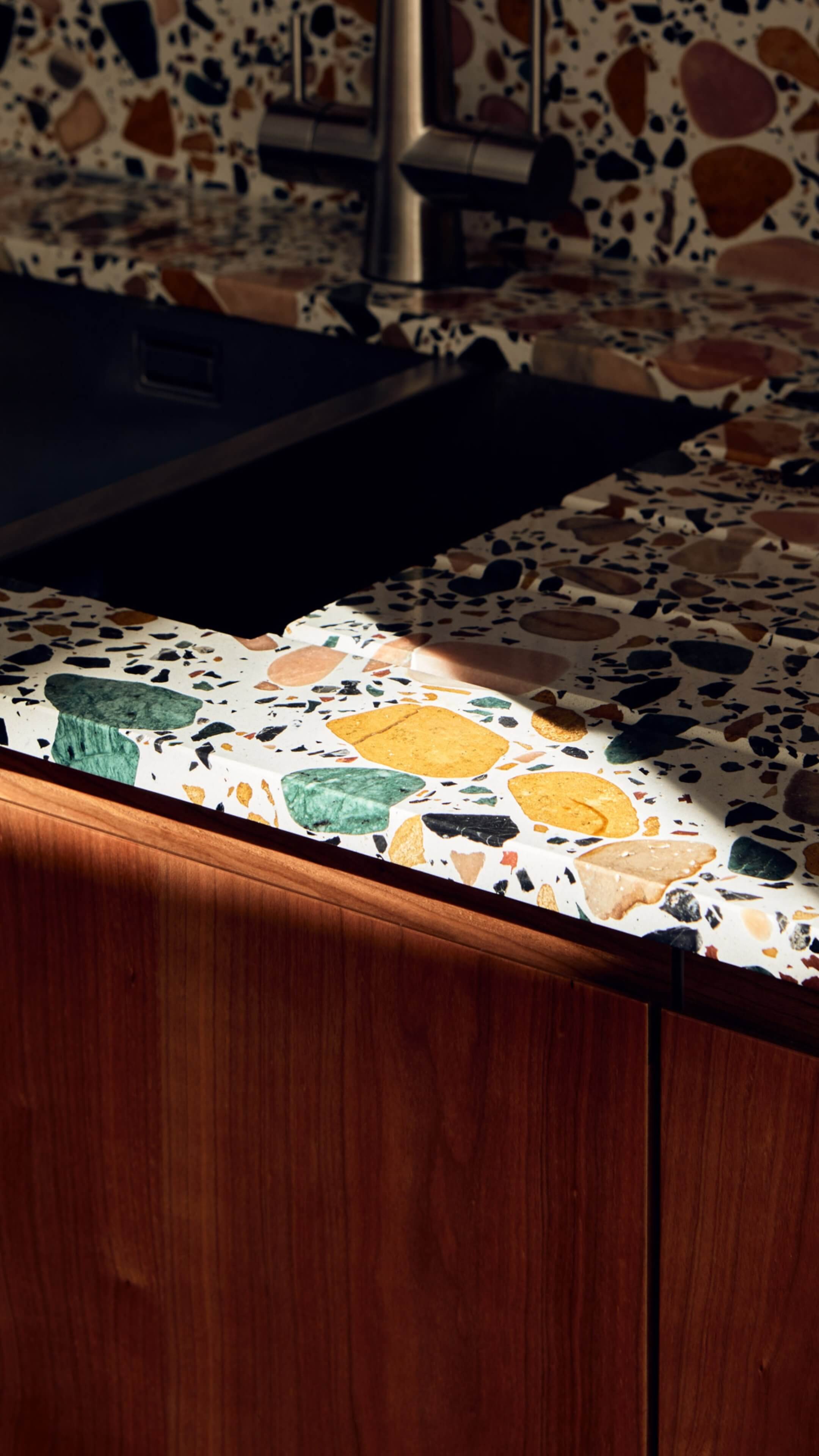 Close up photo of terrazzo worktop with ray of light across half the worktop